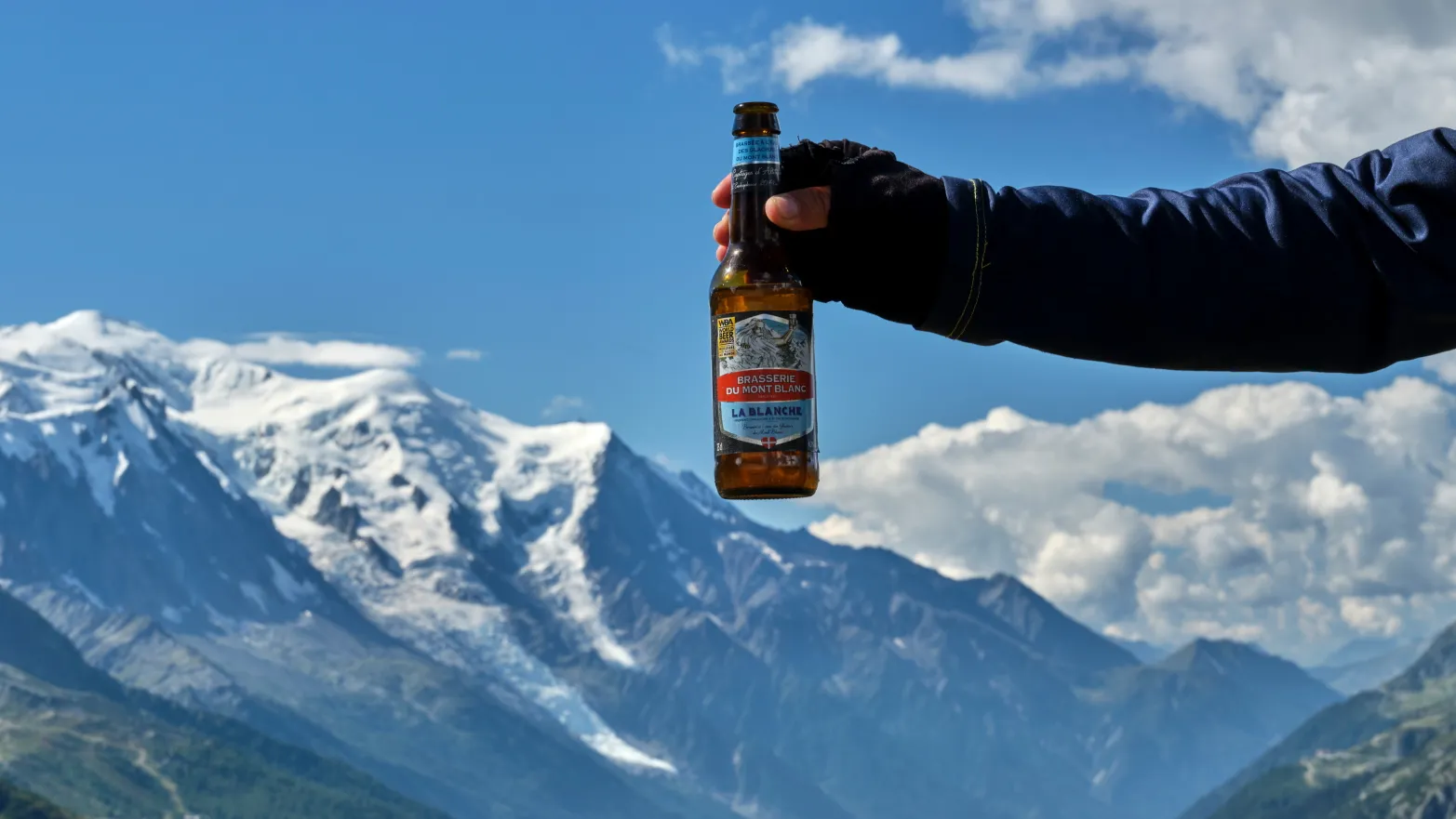 láhev piva s horami v pozadí